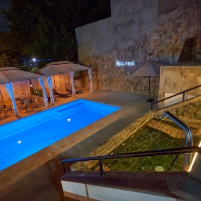 Piscina iluminada y jacuzzi en Alacarta VIP Medellín, ideales para relajarse y socializar.
