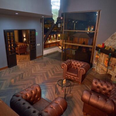 Sala principal de Alacarta VIP con chimenea y sofás de cuero en Medellín.