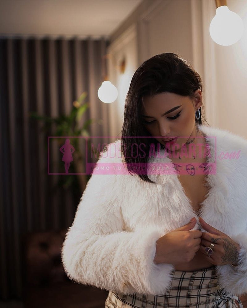 Retrato artístico en blanco y negro de una mujer con tatuajes, mirada intensa y aura misteriosa