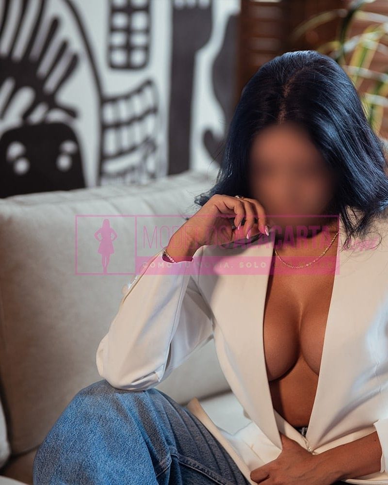 pelinegra ardiente en Bogotá posando con seguridad en lencería negra, resaltando su figura tonificada y elegante.