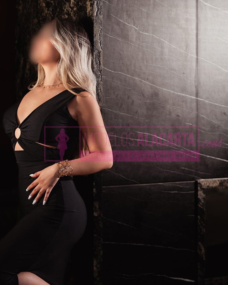 Chica rubia con aire sofisticado, labios protagonistas y mirada envolvente.