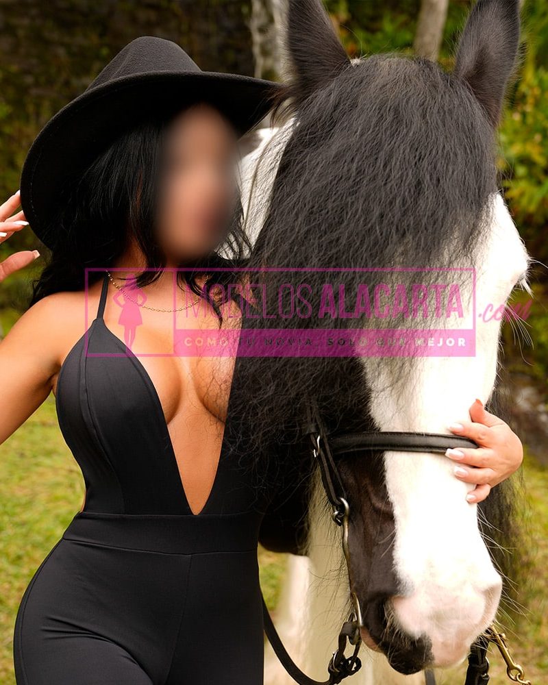 Mujer madura rica en Medellín, Naty Gold, acariciando suavemente un caballo, mostrando su conexión con los animales y su energía positiva