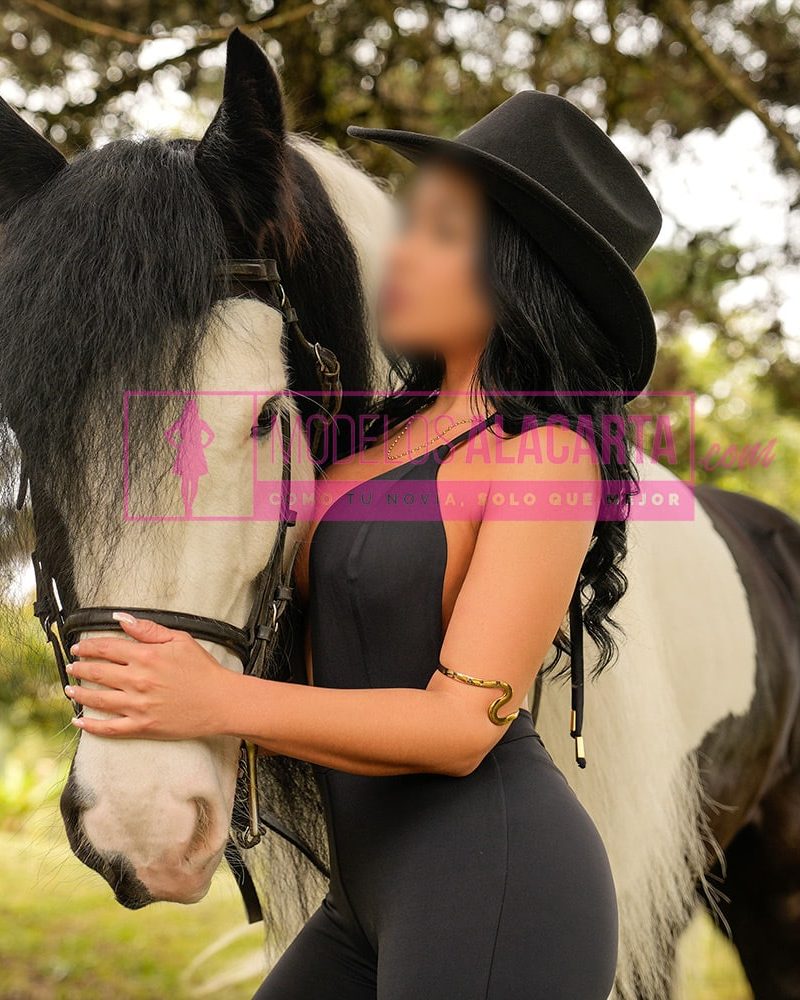 Mujer madura rica en Medellín, Naty Gold, caminando al lado de un caballo en un entorno natural, irradiando energía positiva y armonía con la naturaleza